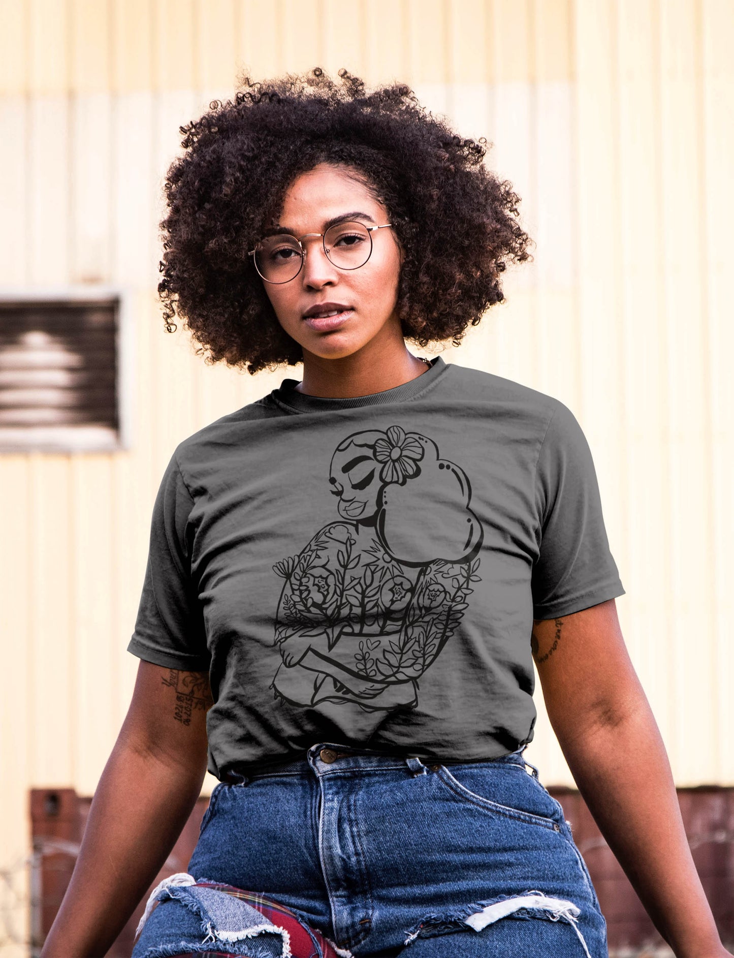 black woman with curly afro and glasses wearing Bouquet Skin T-Shirt in dark grey. mogigi.shop
