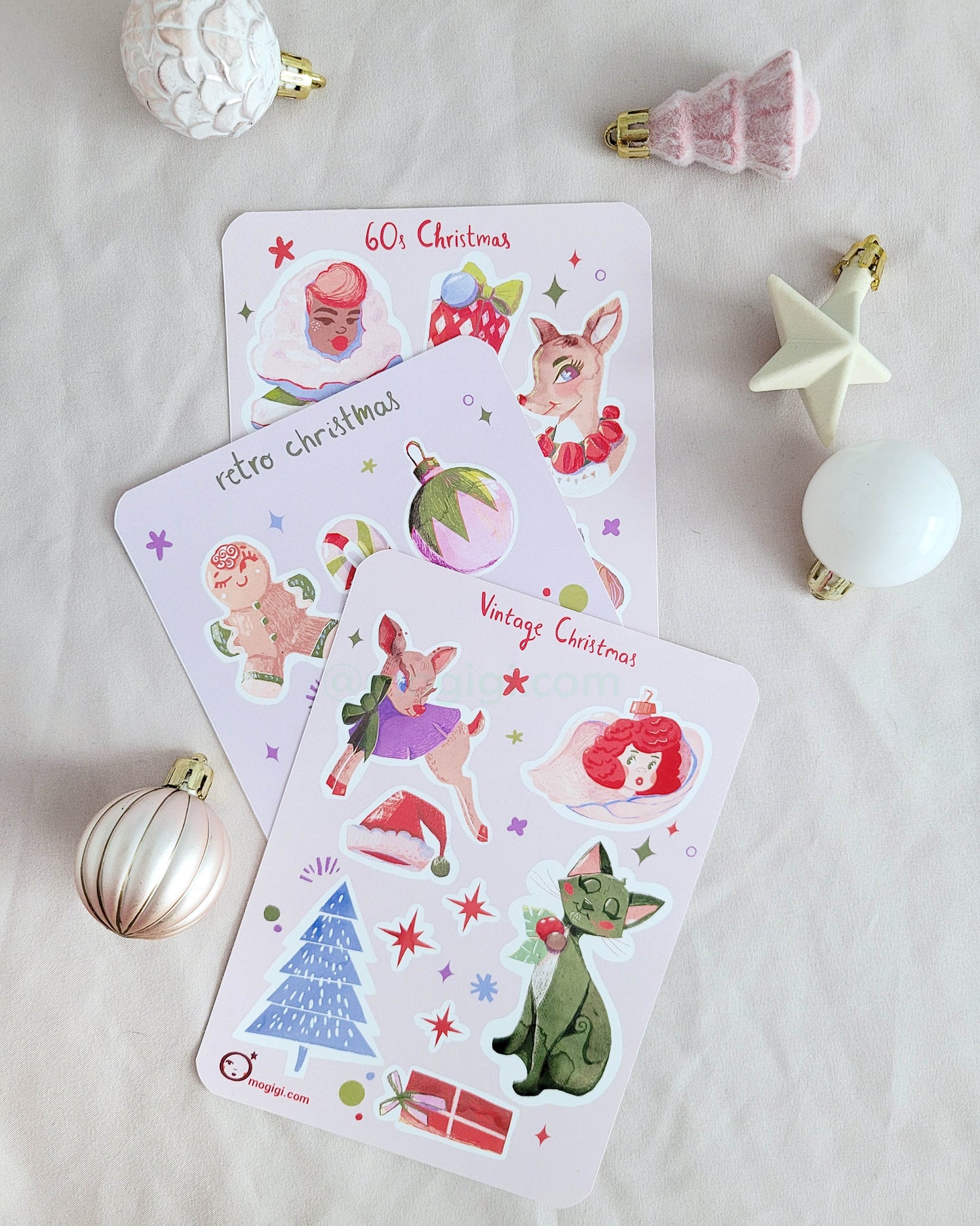 Group of retro style vintage Christmas sticker sheets on white background with mini holiday decorations. gingerbread, candy cane, angel, tree, cat, stars, lights, santa claus, winter, party, 1950s