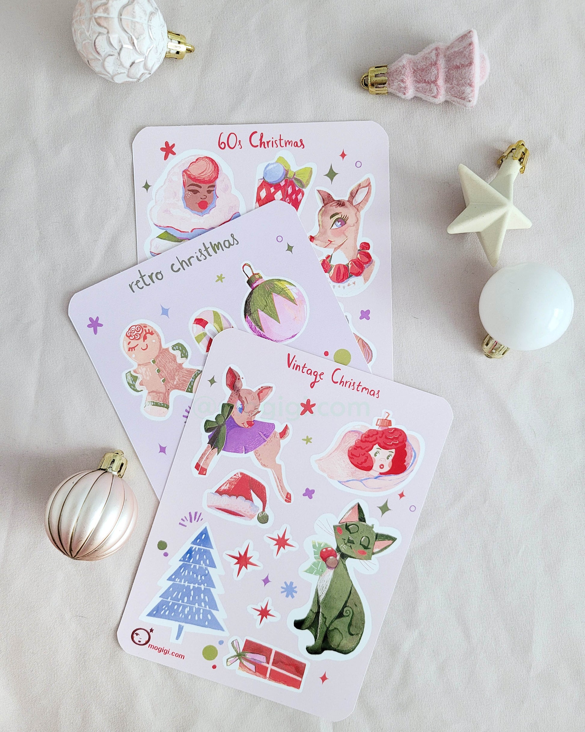 Group of retro style vintage Christmas sticker sheets on white background with mini holiday decorations. gingerbread, candy cane, angel, tree, cat, stars, lights, santa claus, winter, party, 1950s