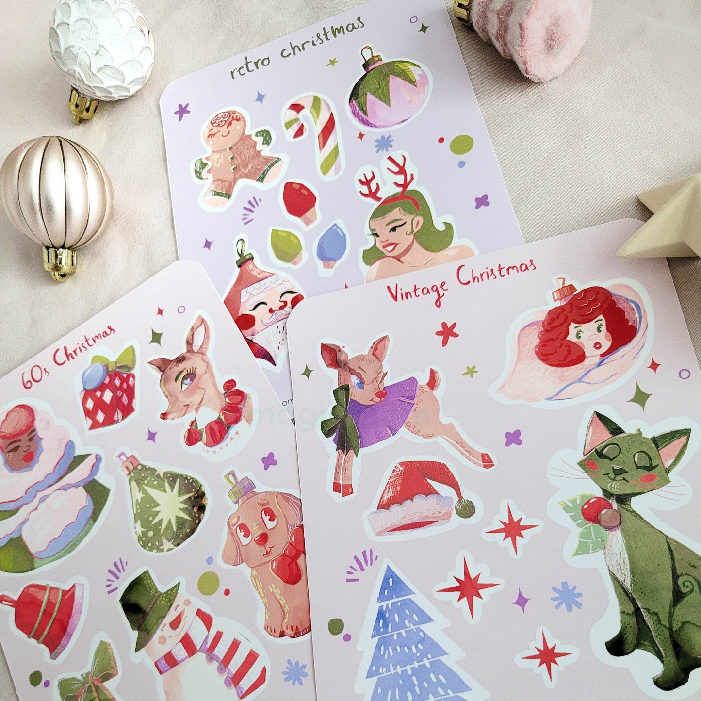 Group of retro style vintage Christmas sticker sheets on white background with mini holiday decorations. gingerbread, candy cane, angel, tree, cat, stars, lights, santa claus, winter, party, 1950s